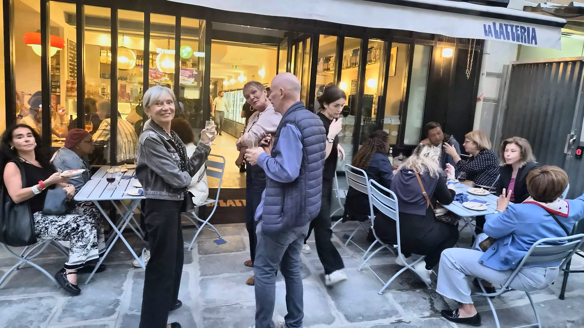 Terrasse de La Latteria, rue du faubourg Poissonnière à Paris, pendant un Aperitivo Italiano Spritz Connection, convives debout et attablés un verre à la main